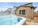Backyard showcasing a hot tub and stone facade with a view of neighboring houses at 7875 S Grand Baker St, Aurora, CO 80016