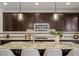 Contemporary kitchen with a granite countertop island, stylish barstools, and pendant lighting at 7875 S Grand Baker St, Aurora, CO 80016