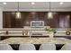 Modern kitchen featuring a large island, stainless steel appliances, and dark wood cabinets at 7875 S Grand Baker St, Aurora, CO 80016