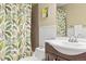 Clean bathroom with a shower/tub combo, white sink, and tropical shower curtain at 2795 S Lansing Way, Aurora, CO 80014