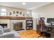 Cozy living room featuring a fireplace, built-in shelving, and hardwood floors at 2795 S Lansing Way, Aurora, CO 80014