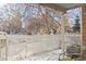 Cozy covered patio with white picket fence and winter scenery at 2795 S Lansing Way, Aurora, CO 80014