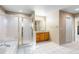 Bright bathroom with tiled floors, glass-enclosed shower, and wood cabinets at 634 E 130Th Way, Thornton, CO 80241
