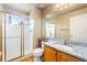 Bathroom featuring granite countertop, wood floors, and glass shower doors for a spa-like feel at 634 E 130Th Way, Thornton, CO 80241