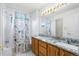 Bathroom boasts granite double sinks, a floral shower curtain, and a full bathtub at 634 E 130Th Way, Thornton, CO 80241