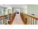 Carpeted second story hallway with wood railings overlooking the downstairs at 634 E 130Th Way, Thornton, CO 80241