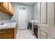 Well-equipped laundry room with sink, granite countertops, and modern washer/dryer units at 634 E 130Th Way, Thornton, CO 80241
