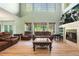 Spacious living room features a fireplace, large windows, and comfortable leather furniture at 634 E 130Th Way, Thornton, CO 80241