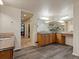 Spacious bathroom featuring a dual vanity, tile countertops, and wood-look tile floors at 10371 Knollside Dr, Parker, CO 80134