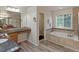 Bright bathroom features a granite countertop vanity, soaking tub and tiled surround at 10371 Knollside Dr, Parker, CO 80134