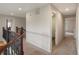 Well-lit hallway with carpet flooring, neutral paint, and decorative wrought iron railing at 10371 Knollside Dr, Parker, CO 80134