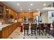 Open-concept kitchen and living area with oak cabinets, stainless steel appliances, tile floors, and a kitchen island at 10371 Knollside Dr, Parker, CO 80134