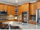 Spacious kitchen with oak cabinets, granite countertops, stainless steel appliances, and a functional island at 10371 Knollside Dr, Parker, CO 80134
