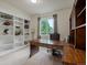 Traditional home office with custom built-in bookshelves, desk, and large window offering natural light at 10371 Knollside Dr, Parker, CO 80134