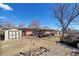 A home's expansive backyard featuring a shed, mature trees, and a well maintained lawn at 12060 W Carolina Dr, Lakewood, CO 80228