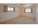 Neutral bedroom with a ceiling fan and natural light from two windows with wood trim at 12060 W Carolina Dr, Lakewood, CO 80228