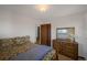 Bedroom with warm carpet, dresser, floral bedding, and natural light from the two windows at 12060 W Carolina Dr, Lakewood, CO 80228