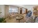 Bright living room with large window, comfortable seating and hardwood floors visible in adjoining room at 12060 W Carolina Dr, Lakewood, CO 80228