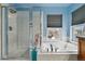 Bathroom featuring glass-enclosed shower, soaking tub by window with tile surround at 2949 Emporia Ct, Denver, CO 80238