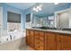 Bathroom featuring double sink vanity with granite countertops and built-in soaking tub by window at 2949 Emporia Ct, Denver, CO 80238