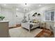 Charming bedroom with a chandelier, cozy swing, and a comfortable white bed and decor at 2949 Emporia Ct, Denver, CO 80238