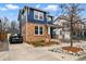 A blue two-story house featuring brick accents, a driveway, and attractive landscaping at 2949 Emporia Ct, Denver, CO 80238