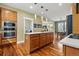 This open-concept kitchen features a large island with seating, built-in appliances, and hardwood floors at 2949 Emporia Ct, Denver, CO 80238