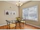 Cozy dining area with a round glass table, seating for two, a modern chandelier, and natural light at 5537 Lewis Ct # 101, Arvada, CO 80002