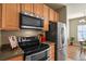 Modern kitchen featuring stainless steel appliances and warm wood cabinetry for storage at 5537 Lewis Ct # 101, Arvada, CO 80002