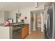 Well-lit kitchen featuring stainless steel appliances, stone countertops, and a view into the laundry area at 5537 Lewis Ct # 101, Arvada, CO 80002