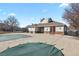 Community pool area featuring a pool cover, the rear of the clubhouse, and a metal fence at 5537 Lewis Ct # 101, Arvada, CO 80002