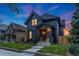 Charming two-story home with dark exterior paint, front porch, landscaped yard, and blue and orange sky at dusk at 2351 N Emerson St, Denver, CO 80205