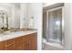 Bright bathroom featuring white countertops, wood cabinetry, and tiled glass enclosed shower at 8711 E Hampden Ave # 22, Denver, CO 80231
