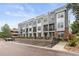 Modern townhome complex with gray siding, brick accents, and rooftop terraces, offering contemporary living at 8711 E Hampden Ave # 22, Denver, CO 80231
