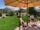 Expansive green backyard with manicured lawn, shade umbrellas, seating, and a view of the storage shed at 3392 Homestead Dr, Longmont, CO 80504