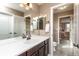 Bright bathroom with double mirrors, wood cabinets, and a view into the next bedroom at 3392 Homestead Dr, Longmont, CO 80504