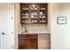 Butler's pantry features cabinets, granite countertop, mosaic backsplash, sink, and mini refrigerator at 3392 Homestead Dr, Longmont, CO 80504