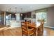 Spacious dining room with hardwood floors, wooden table and chairs, and a view into the modern kitchen at 3392 Homestead Dr, Longmont, CO 80504