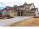 Front exterior of a two-story home with stone accents and three-car garage at 3392 Homestead Dr, Longmont, CO 80504