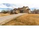Tan two-story home featuring a long driveway and three-car garage at 3392 Homestead Dr, Longmont, CO 80504