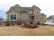 Front exterior of a two-story home with stone accents and three-car garage at 3392 Homestead Dr, Longmont, CO 80504