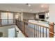 View of the cozy loft area featuring carpet floors, wood and wrought iron railings, and comfortable seating area at 3392 Homestead Dr, Longmont, CO 80504