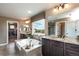 Elegant main bathroom featuring a large soaking tub, dark wood cabinets, granite counters, and modern fixtures at 3392 Homestead Dr, Longmont, CO 80504