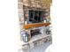 Outdoor stone fireplace with TV, mantle, and decorative lanterns on the porch at 3392 Homestead Dr, Longmont, CO 80504