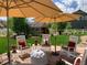 Relaxing stone patio with seating, shade umbrellas and view of the landscaped backyard and storage shed at 3392 Homestead Dr, Longmont, CO 80504