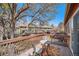 Cozy balcony with seating, a wooden rail, and colorful rug overlooks green space at 2812 W Davies Dr, Littleton, CO 80120