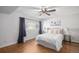 Cozy bedroom with hardwood floors, a ceiling fan, and a queen bed bathed in natural light at 2812 W Davies Dr, Littleton, CO 80120