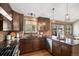 Beautiful kitchen with brick accents, dark wood cabinets, granite countertops, and stainless steel appliances at 2812 W Davies Dr, Littleton, CO 80120