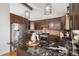 Kitchen features stainless appliances, a center island, brick backsplash, and stylish pendant lights at 2812 W Davies Dr, Littleton, CO 80120