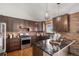 Modern kitchen with stainless steel appliances, stylish lighting, and a brick accent wall at 2812 W Davies Dr, Littleton, CO 80120